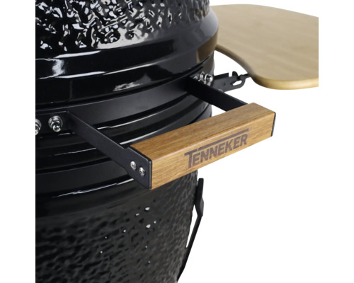 Detailopname van een keramische barbecue met houten handgreep en Tenneker logo