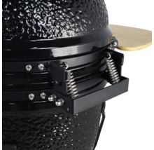 Detailweergave van een zwarte keramische barbecue met veermechanisme en houten plank