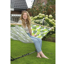 Vrouw ontspant in hangmat met bladerpatroon in de tuin