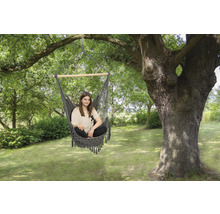 Vrouw zit in een hangmat in de tuin onder een boom