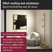 Woonkamer met URail wandlamp, fauteuil en decoratie aan de muur
