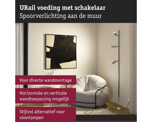 Woonkamer met URail wandlamp, fauteuil en decoratie aan de muur