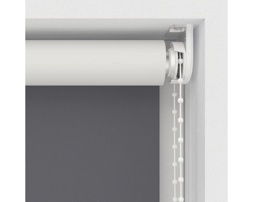 Detailopname van een wit rolgordijn met kettingbediening bij het raam