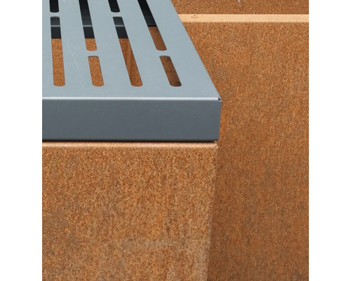 Detailopname van een bank met een metalen zitting en een voet van cortenstaal