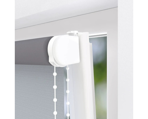 Detailopname van een rolgordijn bij het raam met kettingbediening.