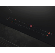 Close-up van een zwarte kookplaat met digitale displays