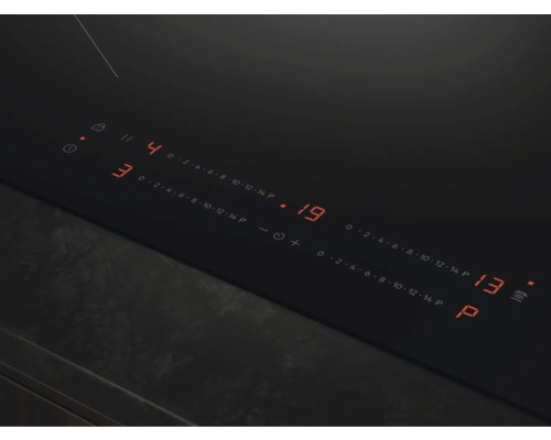 Close-up van een zwarte kookplaat met digitale displays