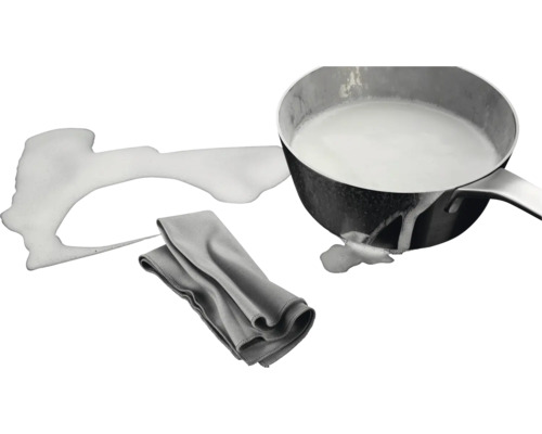 Pan met melk, gemorste melk en schoonmaakdoek
