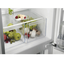 Koelkast met groentelade gevuld met fruit en groente.