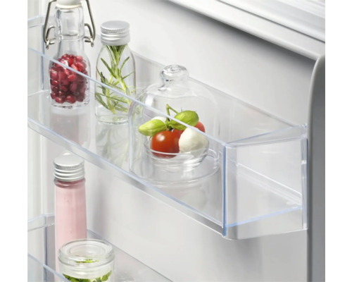 Koelkast met glazen flessen en etenswaren in een transparante plank