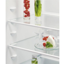 Interieur van een koelkast met levensmiddelen op glazen planken