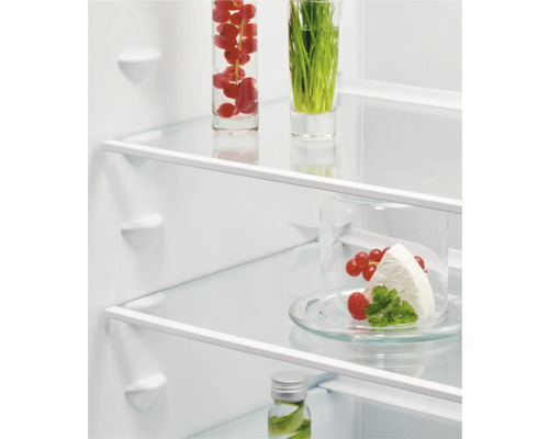 Interieur van een koelkast met levensmiddelen op glazen planken