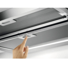 Een afzuigkap met een persoon die een schakelaar bedient.