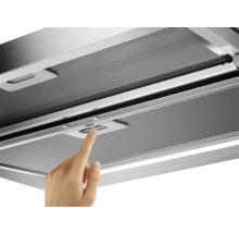 Een hand bedient de schakelaar van een afzuigkap met metalen rooster.