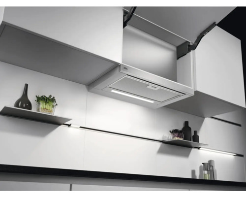 Moderne keuken met afzuigkap onder hangkast en decoratieve artikelen op planken