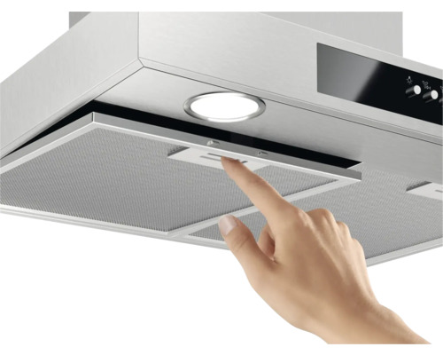 Close-up van een afzuigkap waarbij een hand de filter aanraakt.