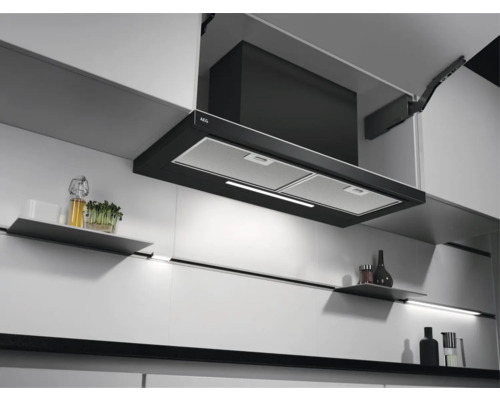 AEG afzuigkap in een moderne keuken met witte kasten en planken.