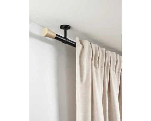 Zwarte gordijnroede met houten eindknop en plafondsteun, waaraan een beige gordijn hangt.