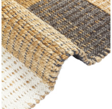 Detailopname van een vloerkleed met verschillende weefpatronen en materialen