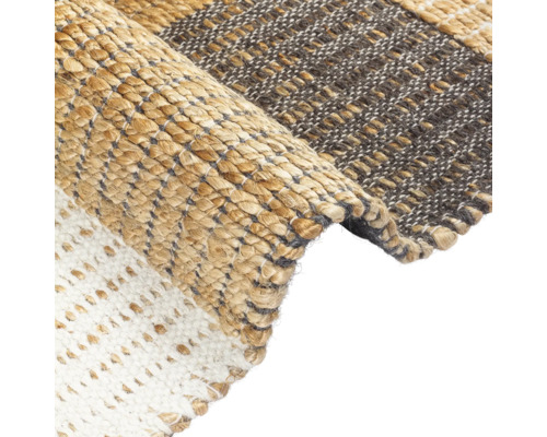 Detailopname van een vloerkleed met verschillende weefpatronen en materialen