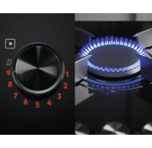 Close-up van een gaskookplaat met bedieningsknop en blauwe vlam