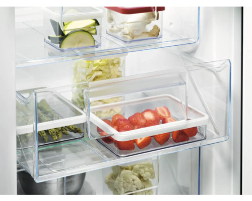 Interieur van een koelkast met groenten en fruit in transparante bakken