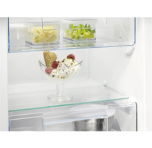 Interieur van een koelkast met etenswaren op glazen planken