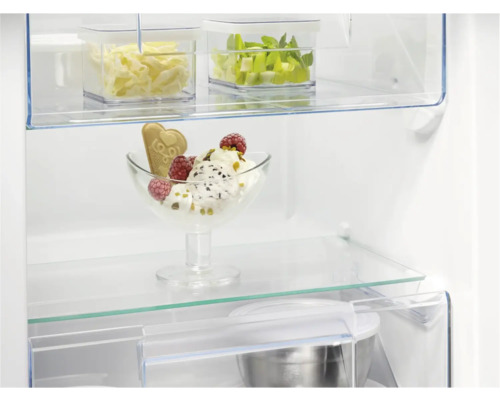 Interieur van een koelkast met etenswaren op glazen planken