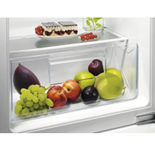 Koelkast met groentelade gevuld met fruit en gebak