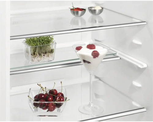 Koelkast met glazen planken en diverse voedingsmiddelen in schalen