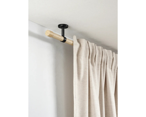 Houten gordijnroede met zwarte plafondsteun en beige gordijn met textuur.