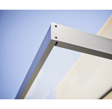 Detailopname van de hoekverbinding van een deurluifel met metalen frame en glaselement.