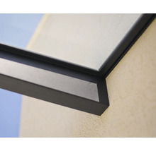 Detail van een donker aluminium frame voor een terrasoverkapping met glaselement aan een buitenmuur.