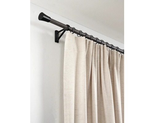 Gordijnroede in donkere houtlook met zwarte metalen ringen en wandsteun, inclusief een beige gestructureerd gordijn.