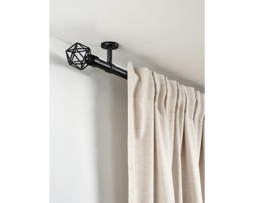 Zwarte metalen gordijnroede met geometrische eindknop en plafondsteun, voorzien van een beige gordijn.