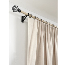 Gordijnroede in houtlook met zwarte metalen ringen, muursteun, geometrische eindknop en beige gordijn.
