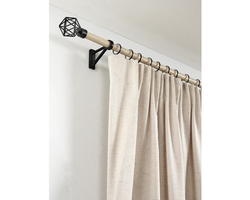 Gordijnroede in houtlook met zwarte metalen ringen, muursteun, geometrische eindknop en beige gordijn.