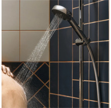 Handdouche met stromend water in een badkamer met tegels