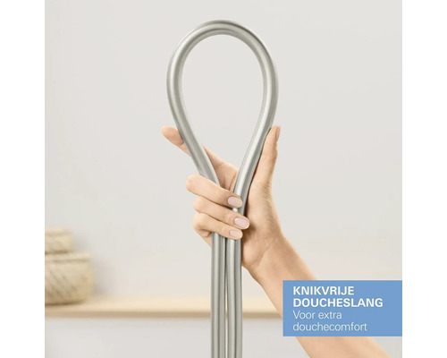Een persoon houdt een flexibele doucheslang van metaal vast.