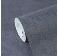 Vliesbehang met fijne linnenstructuur in antraciet, gedeeltelijk afgerolde rol voor wandafwerking.