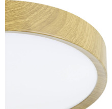 Detailopname van een ronde plafondlamp met houten frame