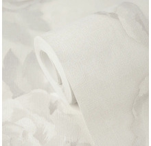 Rol behang met gestructureerd oppervlak en subtiel bloemenpatroon.