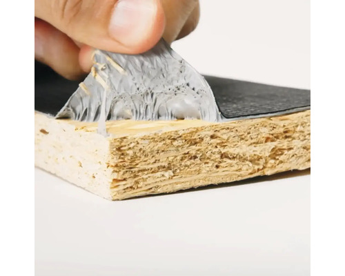 Close-up van een hand die een beschermende folie van een gecoate houten plaat verwijdert