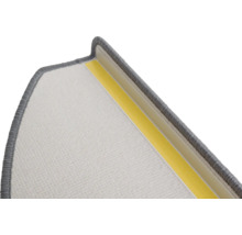 Detail van een trapmat met textieloppervlak en plakstrip voor bevestiging.