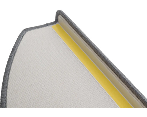 Detail van een trapmat met textieloppervlak en plakstrip voor bevestiging.