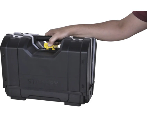 Hand draagt een Stanley gereedschapskoffer aan de handgreep en drukt op de gele ontgrendelknop.