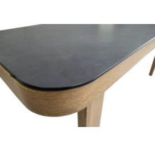 Detail van een eettafel met een stenen tafelblad en houten poten