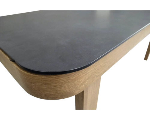 Detail van een eettafel met een stenen tafelblad en houten poten