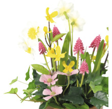 Decoratief kunstbloemstuk met diverse bloemsoorten en groene bladeren.