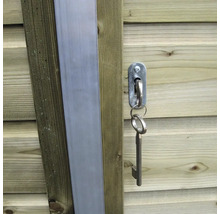 Metalen sleutel in een slot op een houten deur van een tuinhuis.